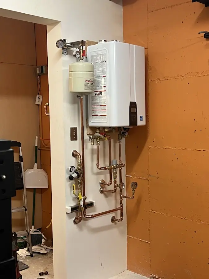 Plumbing technician inspecting water heater connections in Escanaba